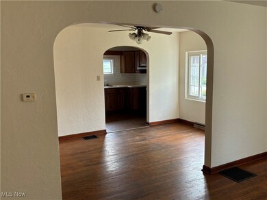 Spare room featuring  ceiling fan, plenty of natural light, and dark wood-type flooring