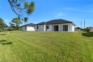 Back of house with a lawn and stucco siding