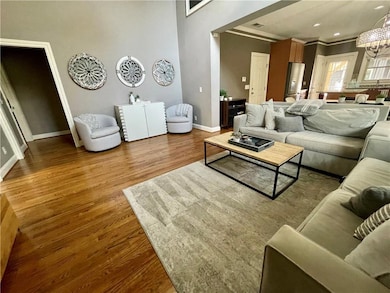 Living area featuring crown molding, wood finished floors, and baseboards