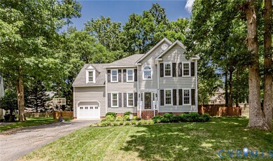 Colonial home featuring asphalt driveway, roof with shingles, entry steps, and an attached garage