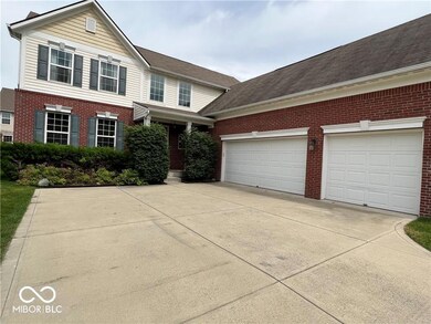 traditional-style house featuring brick siding, driveway, and a garage