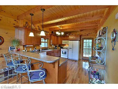 Kitchen. Spacious kitchen has a convenient breakfast bar for those quick meals or entertaining. All appliances remain including a gas stove, microwave, DW and side by side refrigerator. Attractive beam ceilings and a French door to the deck.