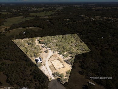 Aerial view of property and surrounding area with a heavily wooded area