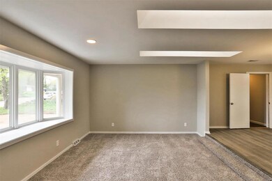 Sunken living room with bay window and skylights.