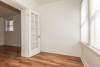 Empty room with healthy amount of natural light and wood finished floors