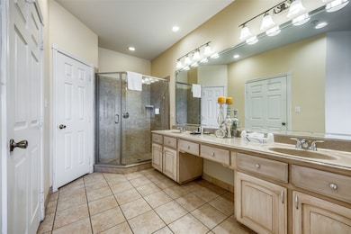 Bathroom featuring walk in shower, vanity, and tile patterned floors
