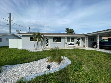 View of front of property featuring a front yard and a carport