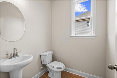 Bathroom with baseboards, a sink, wood finished floors, and toilet