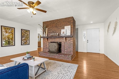 Living area with baseboards, a wood stove, a ceili