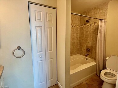 Bathroom featuring toilet, a closet, tile patterne