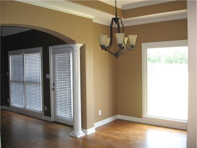 The spacious dining room has arched openings, colu