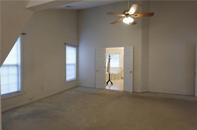 Carpeted spare room featuring a towering ceiling, 