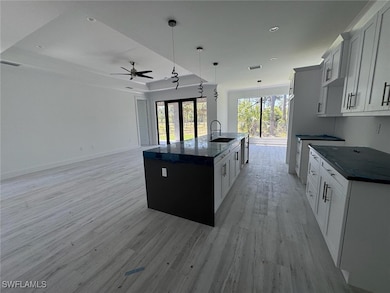 Kitchen featuring an island with sink, a raised ce