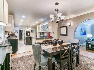 Dining space with ornamental molding, light hardwo
