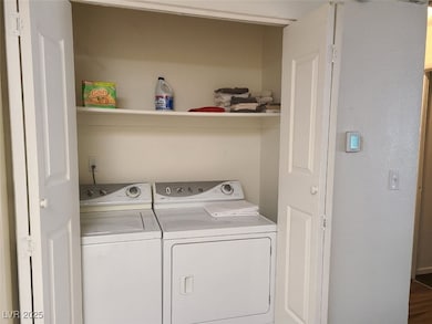 Laundry area featuring independent washer and dryer and a textured wall