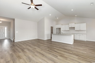 Unfurnished living room featuring high vaulted ceiling, a ceiling fan, recessed lighting, light wood finished floors, and baseboards
