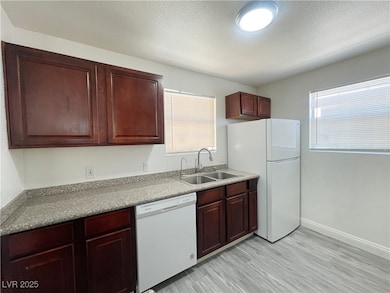 Kitchen featuring white appliances and light wood-style flooring