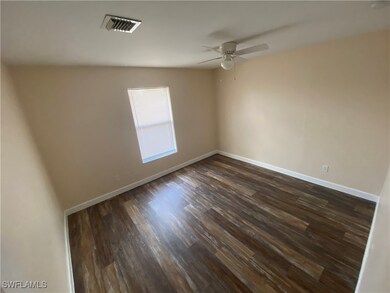 Spare room featuring a ceiling fan, dark wood-type