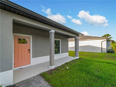 Doorway to property with stucco siding and a lawn