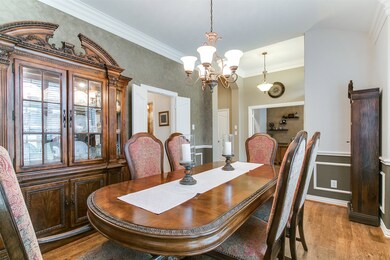 A spacious dining room at the entrance with wood floors, plantation shutters, double crown molding and easy access to the kitchen.