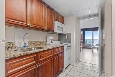 Kitchen with light stone countertops, light tile f