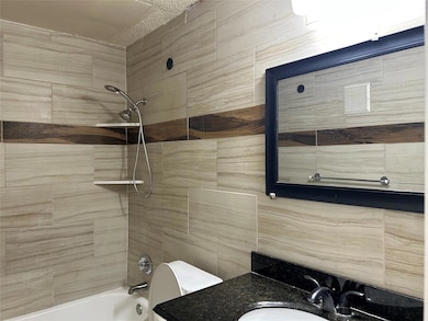 Bathroom with shower / tub combination, toilet, an