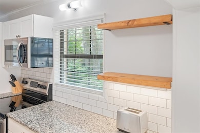 Cottage style open shelving, subway tile and a perfectly placed window with a view of the beautiful front yard.
