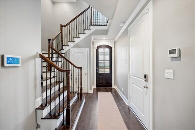 Entryway with stairway, baseboards, and dark wood
