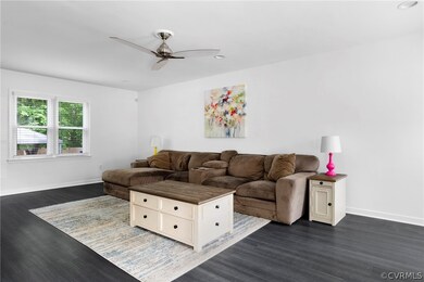 Living room featuring ceiling fan and dark hardwoo