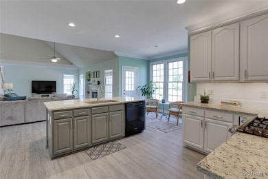 Kitchen with a sink, gray cabinetry, light wood-ty