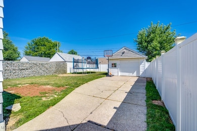 View of yard with a garage, a trampoline, and an outdoor structure