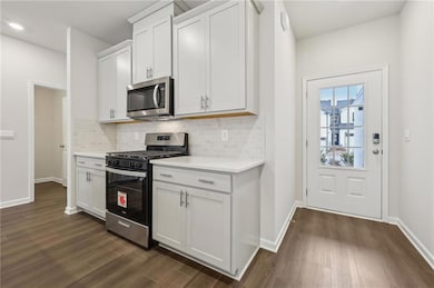 Kitchen featuring dark wood-type flooring, stainle