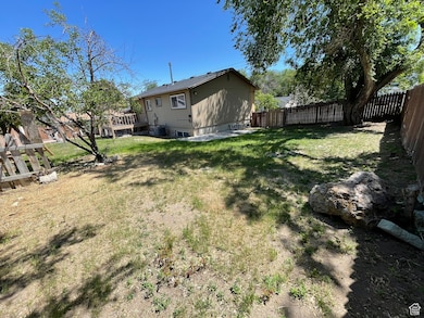Fenced backyard with a wooden deck and a patio