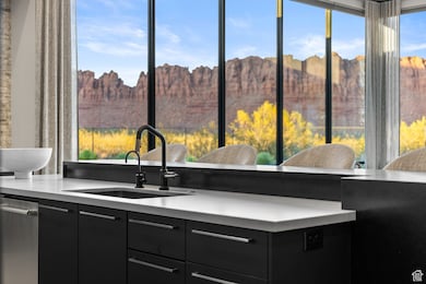 Kitchen with dark cabinetry and a sink