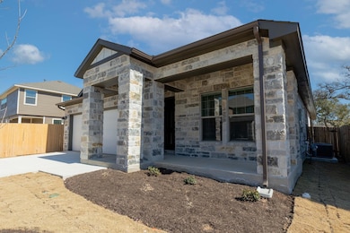 View of front facade featuring stone siding, fenc
