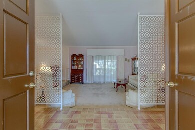 Custom wrought iron screens separate foyer from su