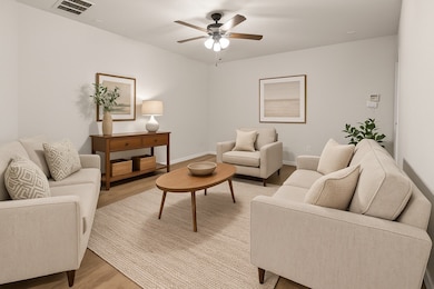 virtually staged Living room with light wood-style flooring and a ceiling fan