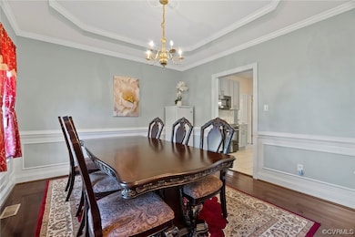 Dining area with a chandelier, a tray ceiling, and