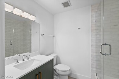 Bathroom with visible vents, a shower stall, baseb