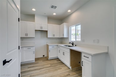 Kitchen featuring white cabinets, light wood-style