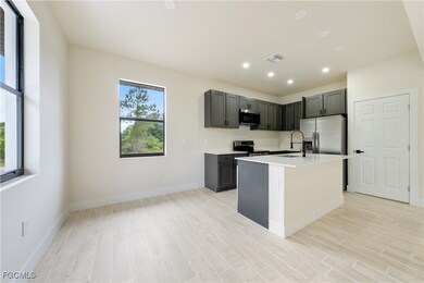 Kitchen featuring stainless steel appliances, light countertops, a kitchen island with sink, light wood-type flooring, and recessed lighting