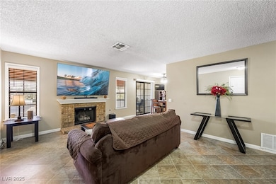 Living room with a brick fireplace and a textured ceiling