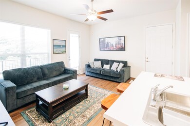 Living area featuring a ceiling fan and wood fini