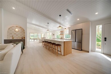 Kitchen with lofted ceiling with beams, open floor