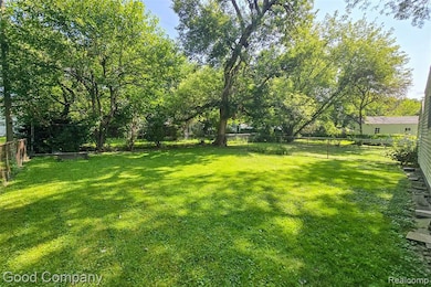 Fenced backyard with view of scattered trees