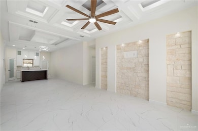 Unfurnished living room featuring a ceiling fan, coffered ceiling, beam ceiling, and light marble finish flooring