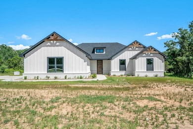 Modern farmhouse style home featuring board and batten siding, a front lawn, and roof with shingles