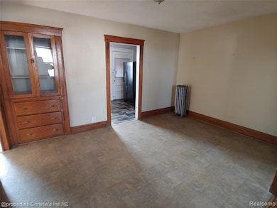 Empty room with radiator heating unit and baseboards