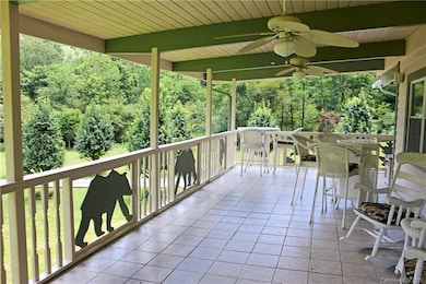 Upper covered deck on front of home with tile floo