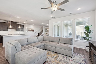 Living room with ceiling fan, light LVP flooring, 
